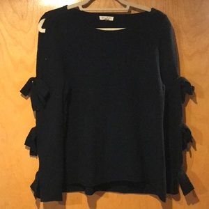 Black sweater top. Arms are cutout with ties